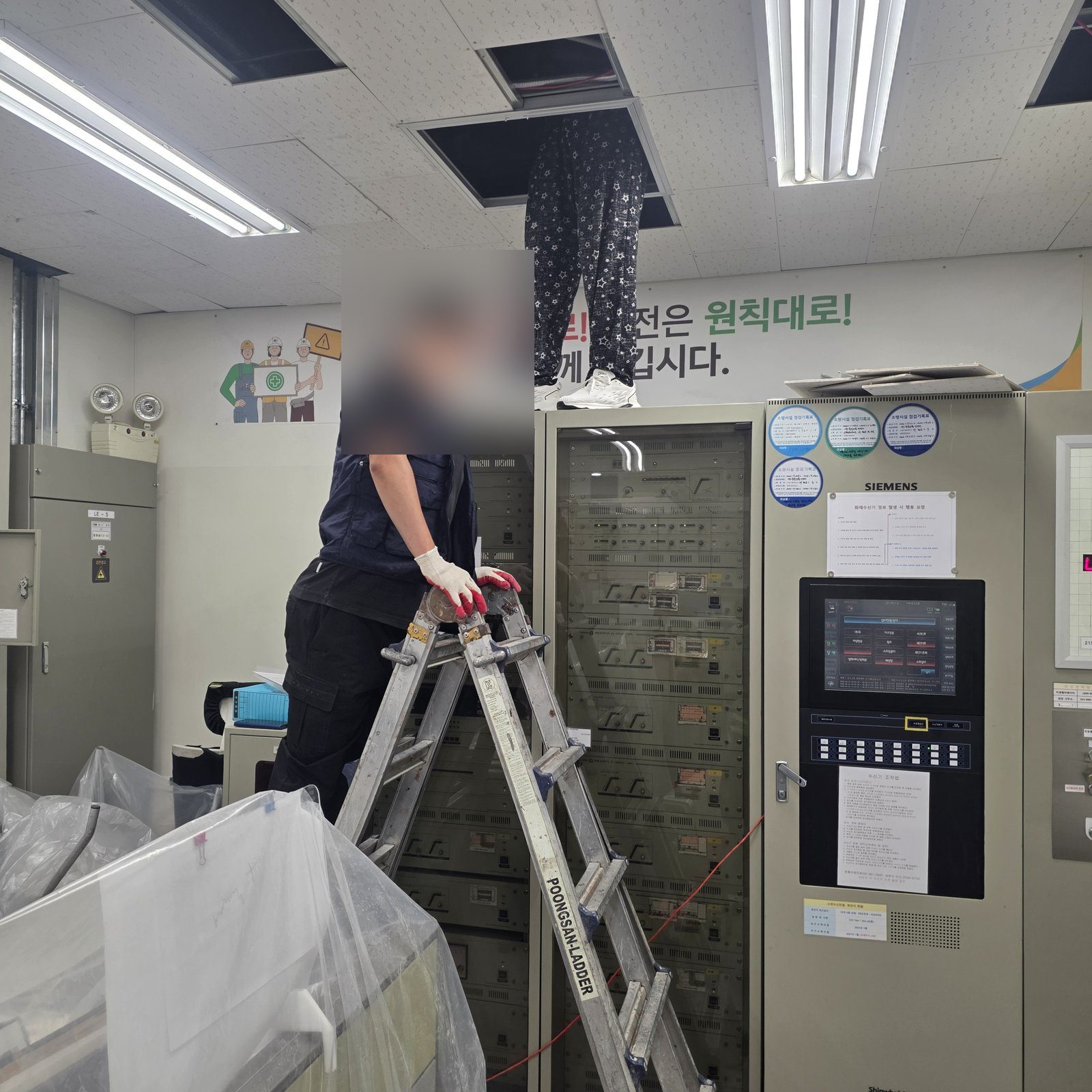새로 낸 점검구 개구부를 통해 천장 속으로 올라간 작업자